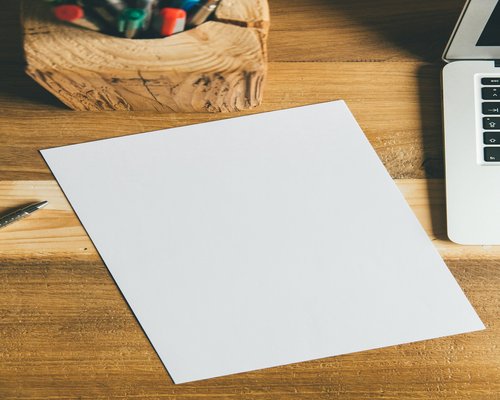 A notebook and a pen on a wooden desk